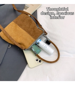 Detail view of two-tone suede shell bag showing interior space for phone and cosmetics