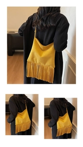Primer plano del bolso de flecos amarillo mostaza con borlas largas y textura de ante