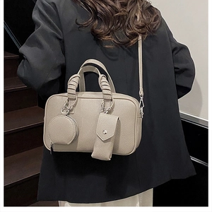Three-in-one elephant grey Boston bag with litchi grain texture on black suit model