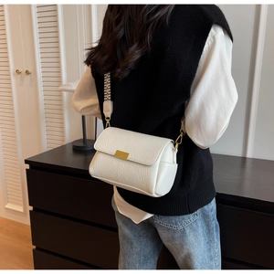 Détail du sac bandoulière blanc texture lychee avec sangle tissée et crochets dorés