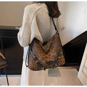 Close-up of leopard print hobo bag with adjustable black straps and silver buckles