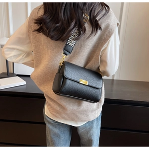 Détail du sac à bandoulière en cuir noir avec large sangle tissée géométrique