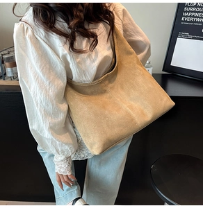 Macro detail of khaki suede hobo bag texture and stitching for professional office carry