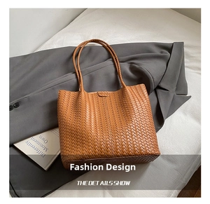 Gros plan d'un sac cabas marron tressé avec motif Intrecciato sur un manteau