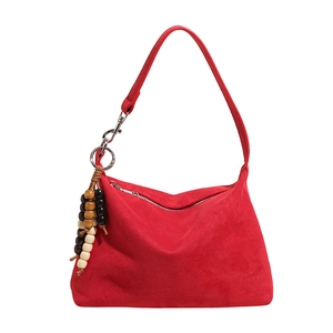 Red suede shoulder hobo bag detail view featuring chic wooden bead charm decoration.