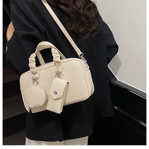 Detail of off-white lychee leather Boston bag with pleated handle and mini pouches