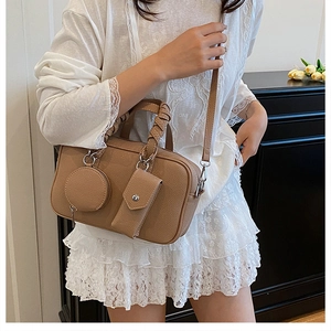 Détail du sac bandoulière rétro motif litchi avec ses pendentifs assortis élégants