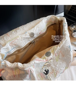 Close-up of bag interior with magnetic snap closure and colorful wave embroidery