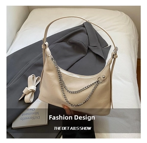 Detail of off-white shoulder bag with double silver chain straps and top zipper closure