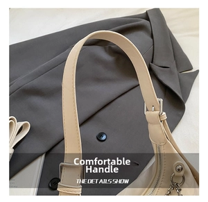 Detail view of smooth cream leather handle with silver metal buckle and refined stitching