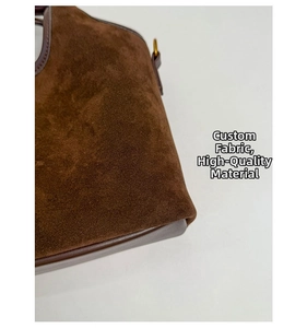 Détails du sac seau en daim marron foncé avec bordures en cuir et ferrures dorées chic