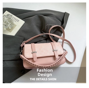 Detailed close-up of pink crossbody bag with woven handle and plaid flap texture