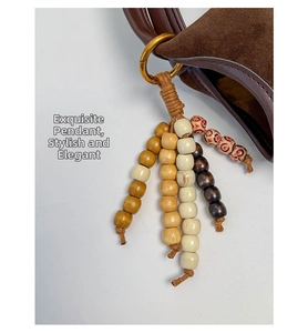 Détail d'un pendentif vintage en perles de bois colorées sur un sac en daim marron