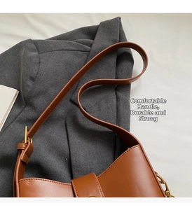 Detalle de bolso de hombro de cuero PU marrón con hebillas metálicas doradas ajustables