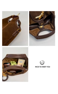 Détail du sac seau en daim marron montrant l'anse en perles de bois et l'intérieur spacieux