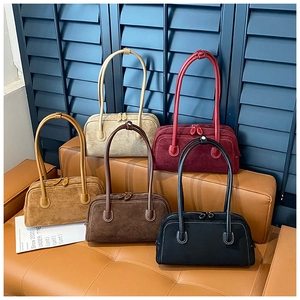 Detailed collection of retro suede underarm bags in five vintage matte colors on a leather seat