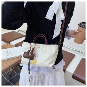Stylish white nylon handbag with brown handle and strap, versatile crossbody bag for women.