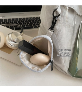 Mini triangle canvas coin purse showing compact storage for lipstick and wireless earbuds