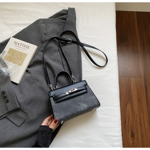 Elegante schwarze Handtasche mit Metallverschluss in einem stilvollen Lifestyle-Szenario