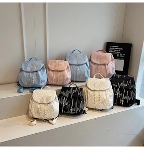 Close-up of quilted nylon mini backpacks with colorful wave embroidery in four colors