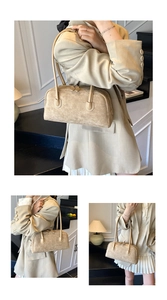 Detail of minimalist beige faux suede baguette bag with double zippers and slim straps
