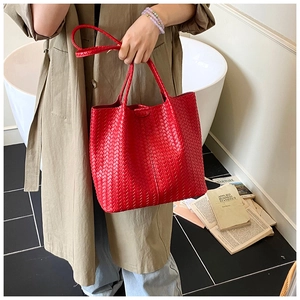 Detail of red woven leather tote bag featuring luxury texture and large capacity style