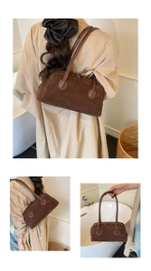 Detail of dark brown suede baguette bag featuring white contrast stitching and dual zippers