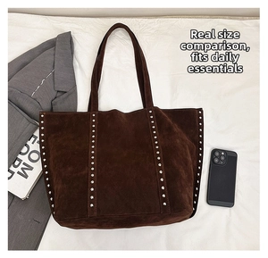 Macro view of dark brown faux suede tote bag featuring silver rivet hardware details