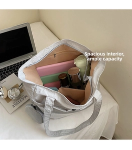 Interior view of grey large capacity tote bag with pockets and separate round pouch