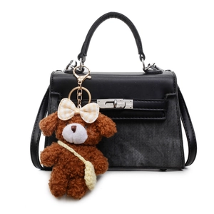 Elegante Handtasche aus schwarzem Leder und Denim mit einem süßen Teddybär-Anhänger.
