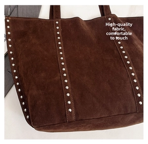 Close-up of vintage brown suede tote bag featuring metallic silver stud detailing
