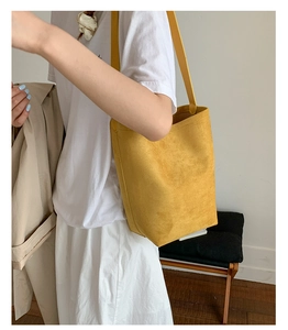 Detailed macro view of ginger yellow bucket bag in premium matte frosted texture