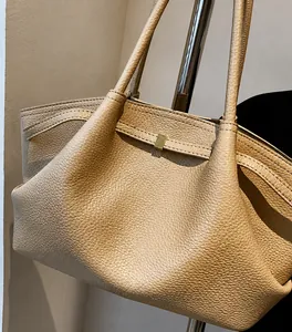 Detail of premium lychee texture leather and square metal buckle on beige tote bag
