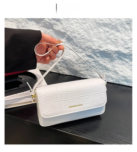 Nahaufnahme der weißen Kunstlederstruktur in Krokodil-Optik dieser eleganten Handtasche