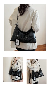 Detail of black glossy leather hobo bag with lazy breeze tag and metallic zipper hardware