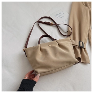 Khaki nylon tote bag detail, featuring brown shoulder strap and large capacity design.