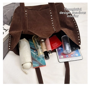 Detail view of large brown faux suede tote bag with silver rivets and spacious interior