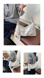Detail of off-white textured leather underarm bag with zipper pockets and Lazy breeze tag
