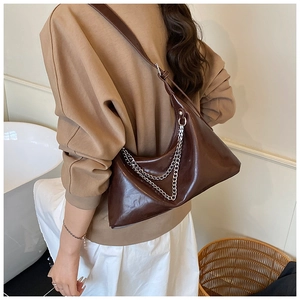 Detailed close-up of brown PU leather hobo bag with dual silver chain ornaments