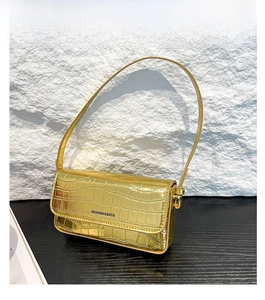 Detailansicht der goldenen Krokodil-Prägung auf der Textur einer modischen Baguette-Tasche