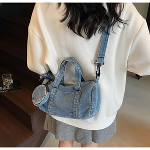 Dettaglio borsa a secchiello in denim lavato blu con pochette e tracolla regolabile