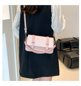 Detail view of woven pattern on pink leather handbag with silver hardware accents