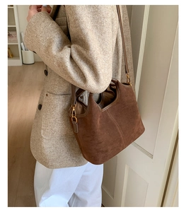 Détails du sac seau vintage en daim marron avec ferrures dorées et coutures précises