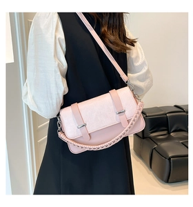 Detail of light pink crossbody bag with waffle texture and braided handle on model