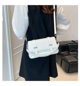 White croc-embossed small square bag with woven handle shown on model in minimal room