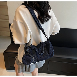 Detail of dark blue denim barrel bag with mini round coin purse and nylon strap