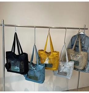 Nylon tote bags in five colors with PVC pockets hanging on a metal rack