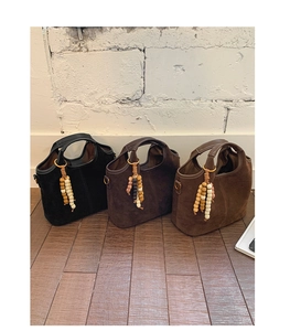 Détail de trois sacs cabas vintage en daim avec des ornements de perles suspendues uniques
