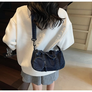 Detail of dark blue denim barrel crossbody bag with detachable round coin purse