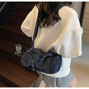 Dettaglio della borsa a cilindro in denim blu con portamonete rotondo e doppia cerniera